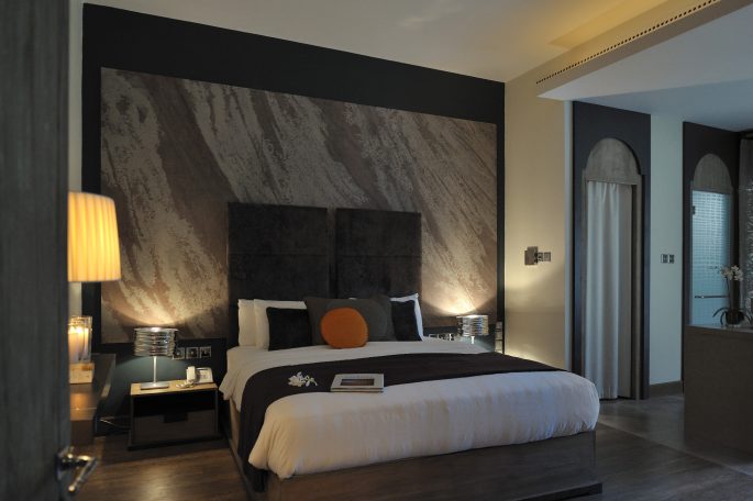 Chambre moderne avec un lit queen, lampes de chevet et décor mural élégant.